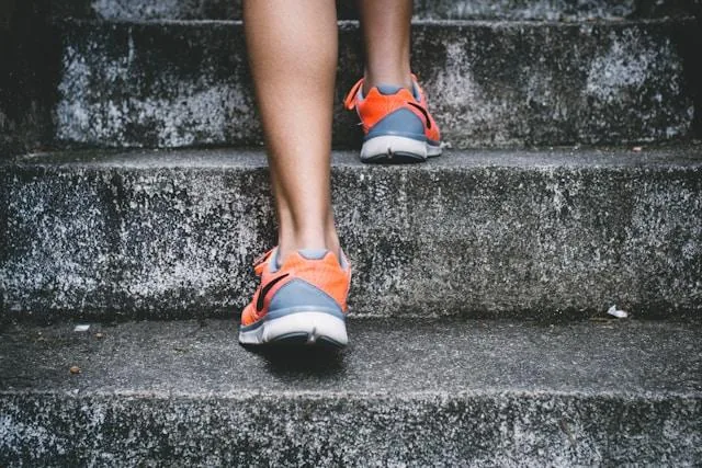 Close-up of running shoes climbing a flight of stone steps