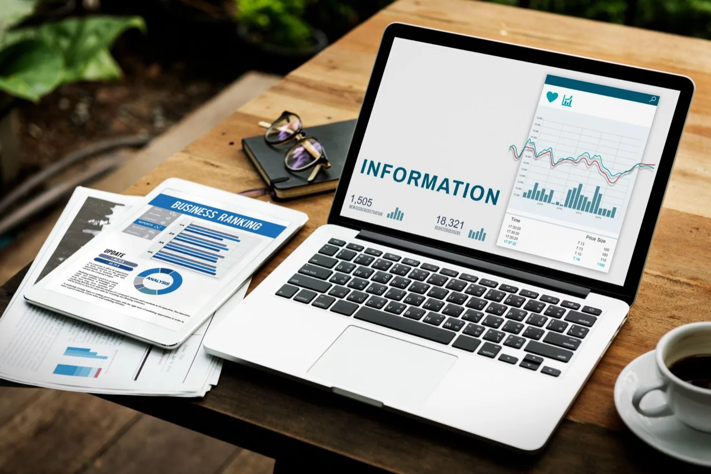 A laptop and tablet on a desk displaying analytics dashboards