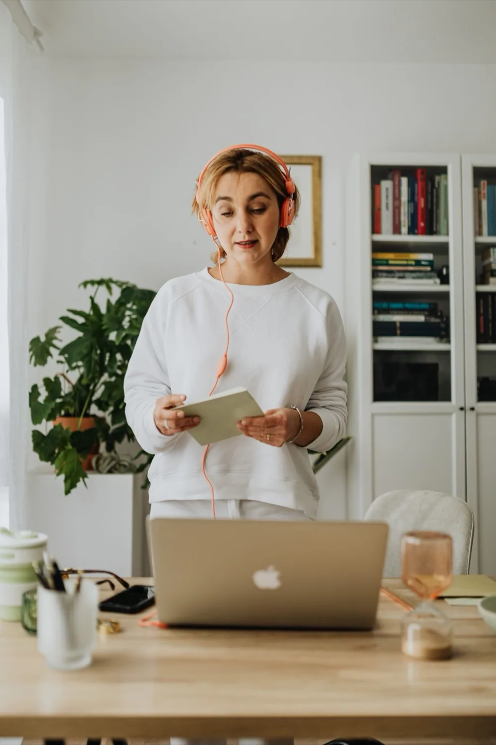 A consultant reviewing her notes during a client call at her desk